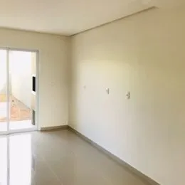 Foto de um corredor interno com paredes brancas e piso claro.