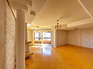 Vista interna de um ambiente amplo com piso de madeira clara.