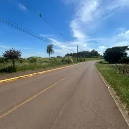 Uma estrada asfaltada se estende sob um céu azul claro.