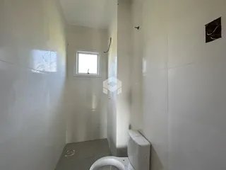Corredor interno com paredes brancas e piso de cerâmica.