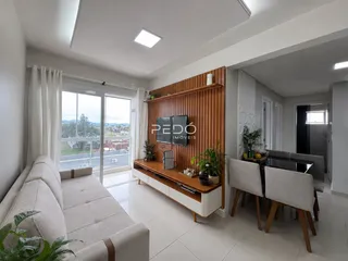 Sala de estar moderna com sofá e portas de vidro abrindo para a vista.