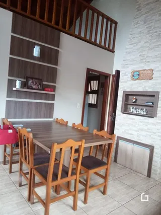 Foto da sala de jantar com mesa e cadeiras de madeira.