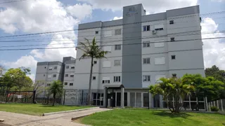 Fachada de um prédio residencial em Lajeado, Brasil, com gramado e árvores no primeiro plano.