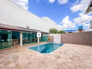 Foto da área de piscina externa com deck de pedra em uma residência.