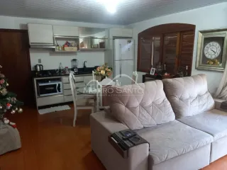 Sala de estar com sofá e armários na cozinha.
