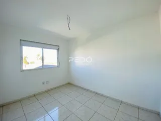Ambiente interno de uma sala com piso de cerâmica e janela.
