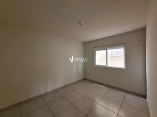 Interior de uma sala com piso de cerâmica e janela.