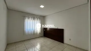 Uma sala de estar com piso de cerâmica e cortinas brancas.