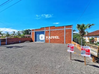 Fachada de um imóvel com paredes de tijolos vermelhos e porta de garagem azul.