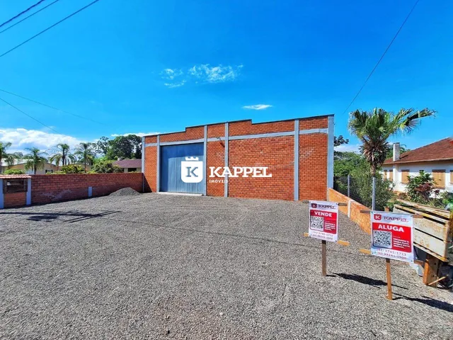 Fachada de um imóvel com paredes de tijolos vermelhos e porta de garagem azul.