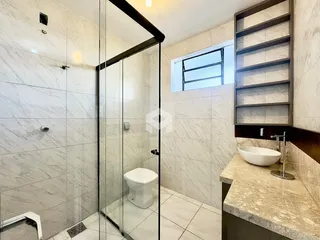 Banheiro moderno com revestimento de mármore nas paredes e piso.
