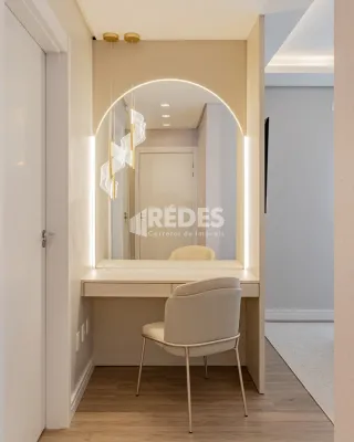 Hall de entrada com porta branca e piso de madeira clara.