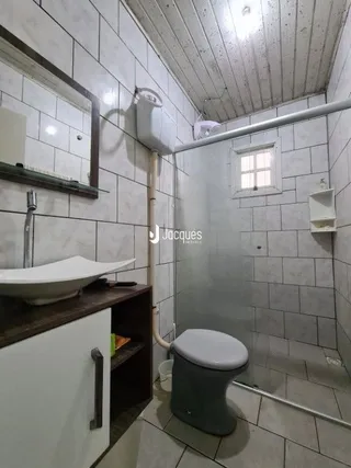 Foto de um banheiro com revestimento cerâmico e box de chuveiro.