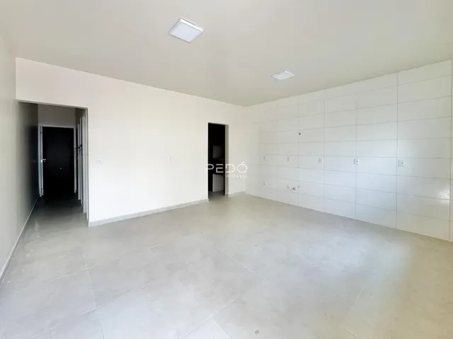Ambiente interno de uma sala ampla com paredes brancas.