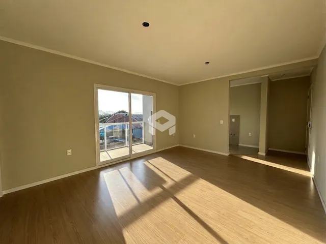 Interior de uma sala com piso de madeira e porta de vidro.