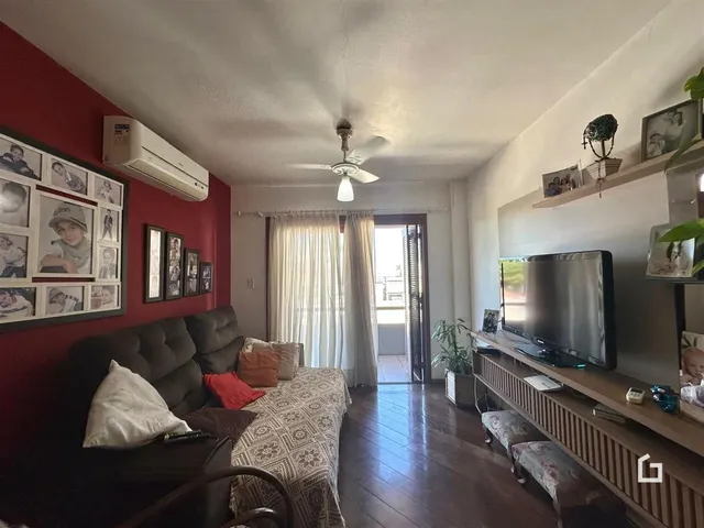 Sala de estar com sofá e cama em ambiente com paredes vermelhas.
