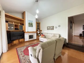 Sala de estar com piso de madeira e lareira em um apartamento em Lajeado.