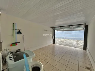Interior de um ambiente com piso de cerâmica e passagem para uma área externa.