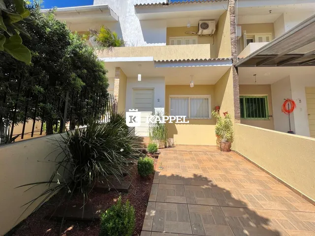 Vista externa de um prédio residencial em Lajeado, com um pátio pavimentado e vegetação.