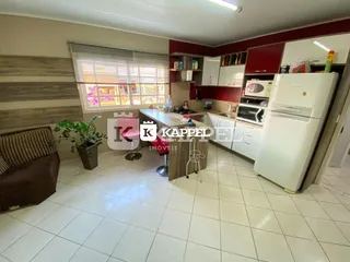 Foto interna de uma cozinha com armários vermelhos e piso de cerâmica.