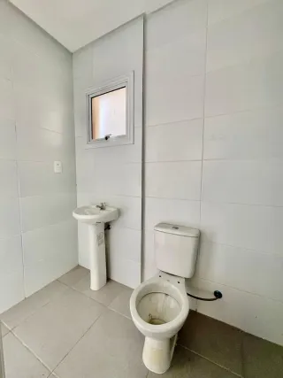 Foto de um banheiro com vaso sanitário branco e piso de cerâmica.