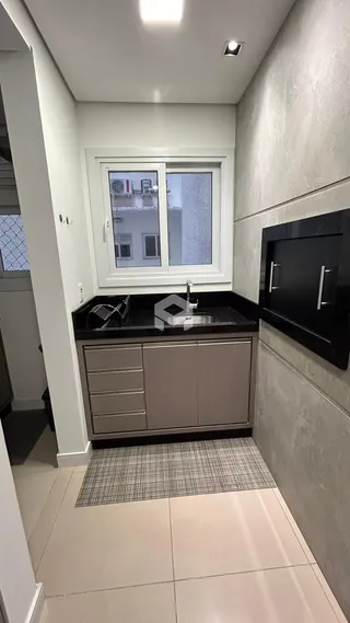 Vista interna de uma cozinha com armários e janela em Lajeado.