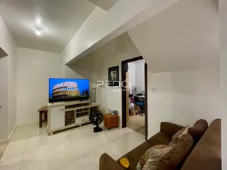 Sala de estar com sofá e televisão em um imóvel no Brasil.