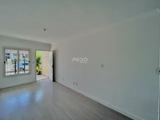 Ambiente interno com piso de madeira clara e paredes brancas.