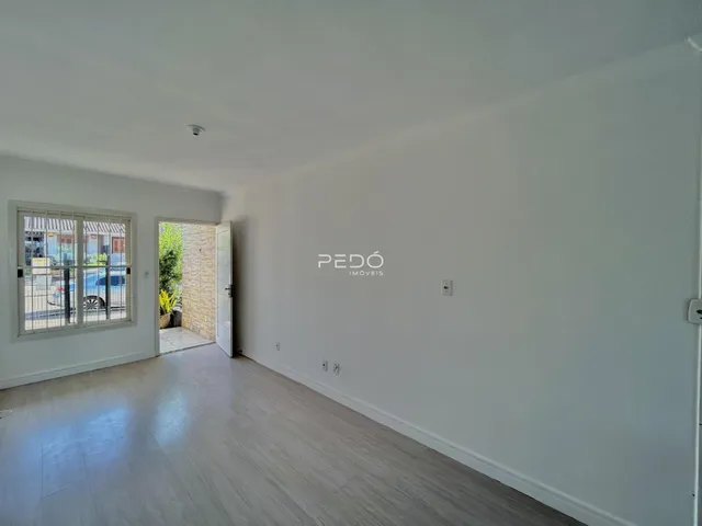 Ambiente interno com piso de madeira clara e paredes brancas.