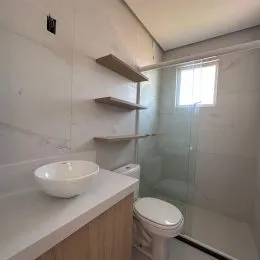 Foto de um banheiro interno mostrando a pia e o vaso sanitário.
