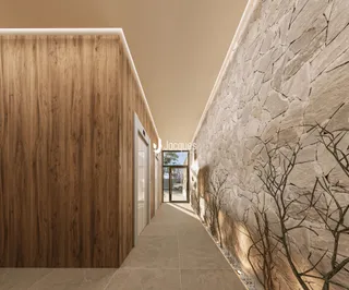 Corredor interno com paredes de madeira e pedra em um imóvel.