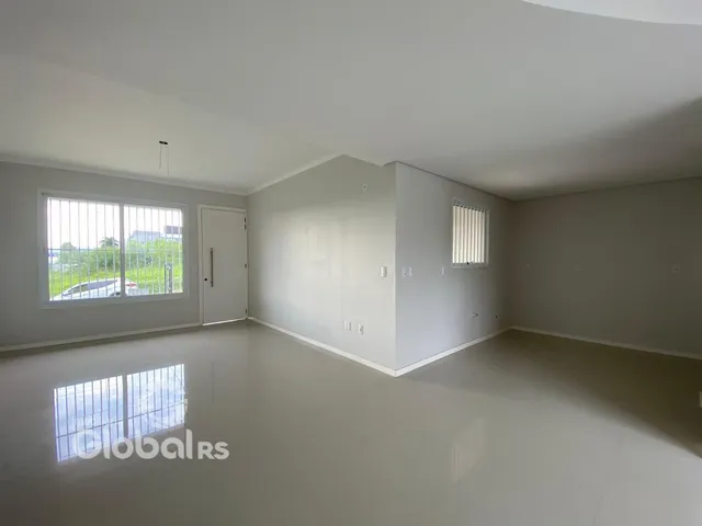 Sala de estar de um imóvel em Lajeado, Brasil, com piso claro e paredes brancas.