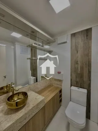 Banheiro com bancada de mármore e armário de madeira visível.