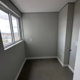 Foto de um cômodo interno com parede cinza e janela.