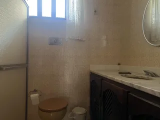Foto interna de um banheiro com revestimento de azulejos brancos e um lavatório.