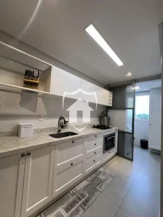 Cozinha moderna com armários brancos e bancadas claras.
