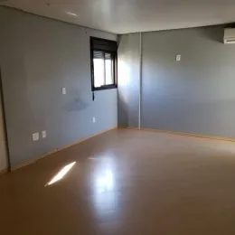 Foto de um cômodo amplo com piso brilhante e paredes claras.