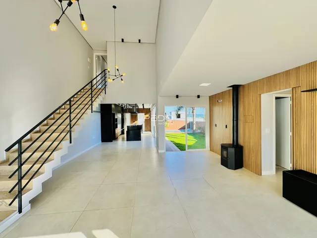 Vista do hall de uma casa moderna com piso de cerâmica e detalhes em madeira.