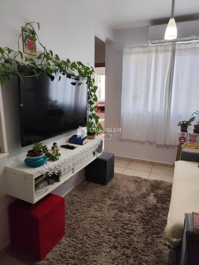 Sala de estar com televisão e decoração na parede.