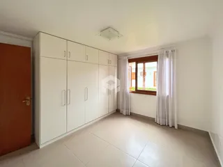Ambiente interno de uma sala com armários embutidos e piso de cerâmica.