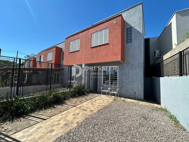 Fachada de uma residência em Lajeado, Brasil, com revestimento vermelho e área externa pavimentada.