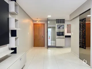 Ambiente interno de um apartamento com piso de cerâmica e estantes brancas.