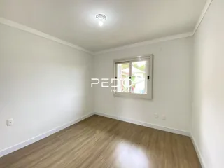 Quarto com piso de madeira e janela.