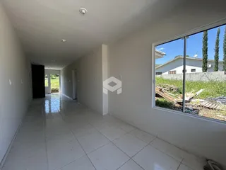 Corredor interno de uma residência com piso de cerâmica branca.