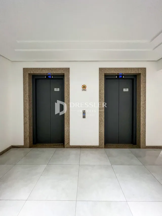 Hall de entrada com portas escuras e paredes brancas.
