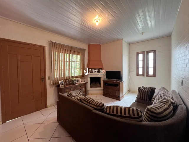 Sala de estar com lareira e porta de madeira em imóvel no Brasil.