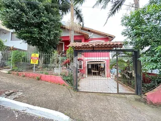 Fachada de uma residência em Lajeado, Brasil, com portão de ferro e cerca.