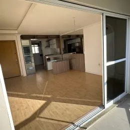 Vista interna de um ambiente com piso claro e passagem para outra área.