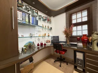 Uma sala de estar com estantes de vidro e decoração de madeira.