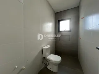 Foto de um banheiro com paredes revestidas de cerâmica e vaso sanitário branco.